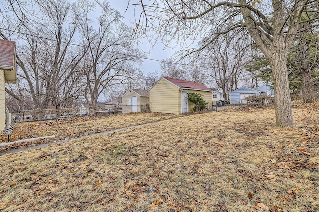 view of yard featuring an outbuilding, fence, and a storage unit