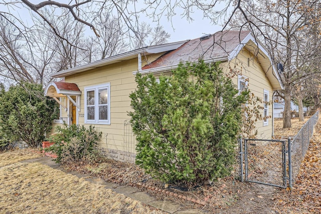 view of property exterior featuring fence and a gate