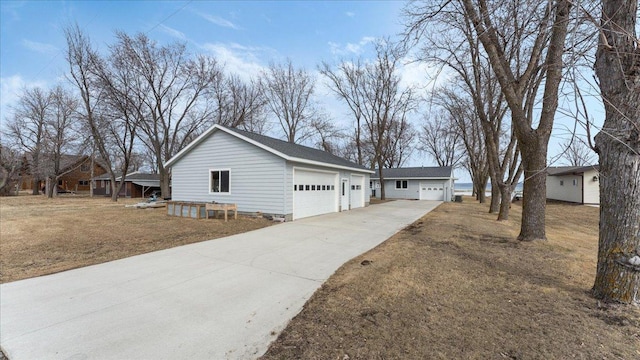 view of property exterior with concrete driveway and a detached garage