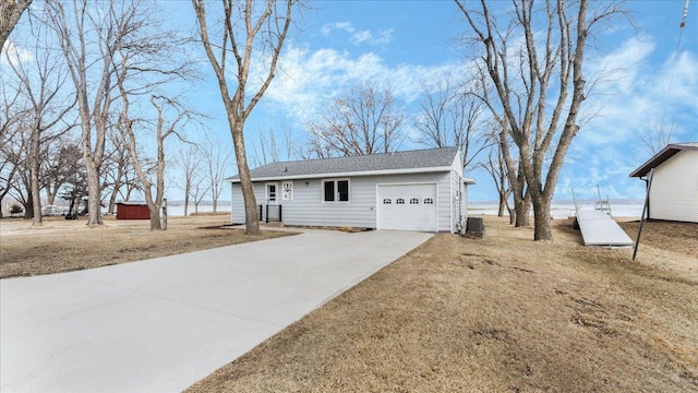 ranch-style home featuring central air condition unit, driveway, and an attached garage