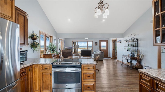 kitchen with dark wood finished floors, an inviting chandelier, stainless steel appliances, glass insert cabinets, and open floor plan