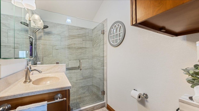 bathroom featuring a stall shower, vanity, and lofted ceiling