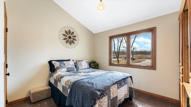 bedroom with vaulted ceiling, baseboards, and carpet floors