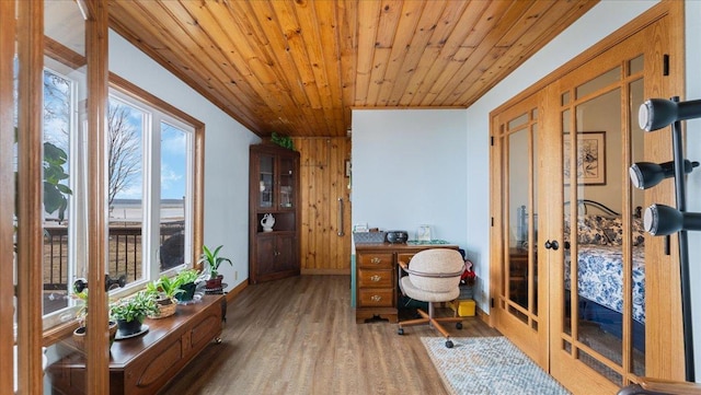 home office featuring french doors, wooden ceiling, baseboards, and wood finished floors