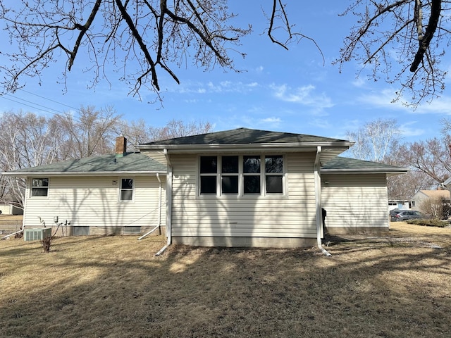 back of property featuring a lawn and a chimney