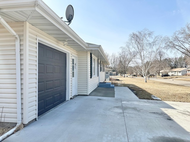 view of side of property with an attached garage and driveway