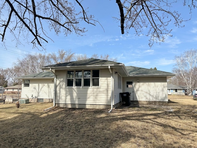 back of property featuring a lawn and central AC unit