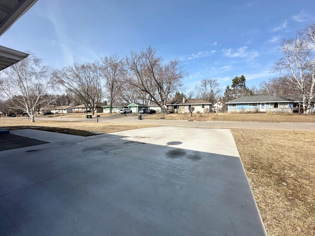 view of yard featuring a residential view and driveway