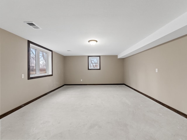 spare room with visible vents, concrete floors, and baseboards