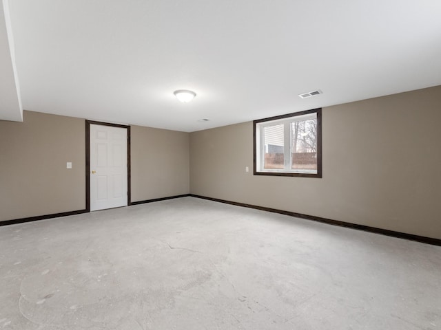 spare room featuring visible vents, concrete floors, and baseboards