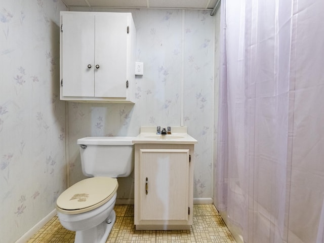 full bathroom with baseboards, toilet, vanity, and wallpapered walls