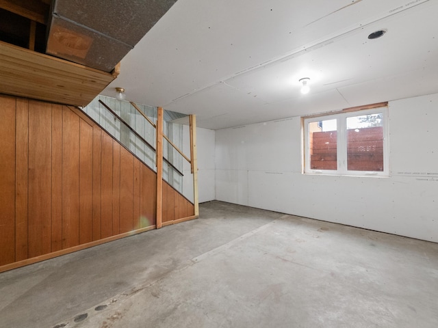 basement with stairway and wooden walls