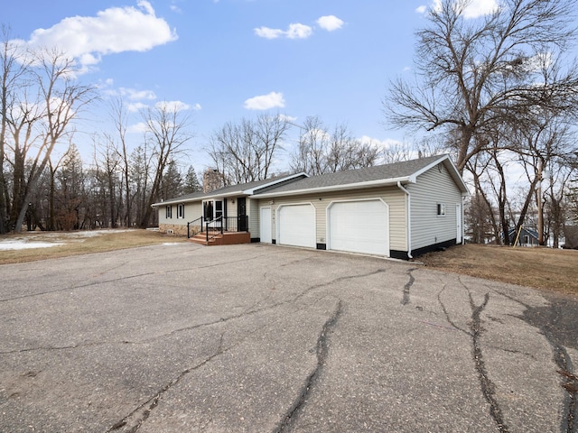 view of front of home with aphalt driveway, an attached garage, roof with shingles, and a chimney