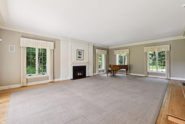 unfurnished living room with visible vents, crown molding, a large fireplace, baseboards, and light wood-style floors