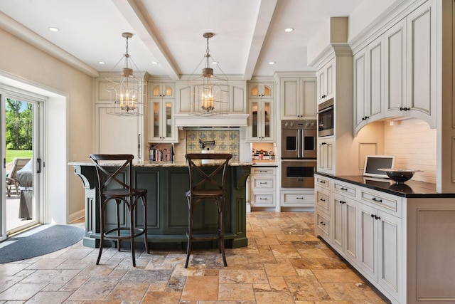 kitchen with tasteful backsplash, double oven, stone tile floors, and a center island