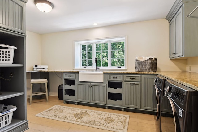 kitchen featuring a sink, gray cabinetry, and washer and clothes dryer