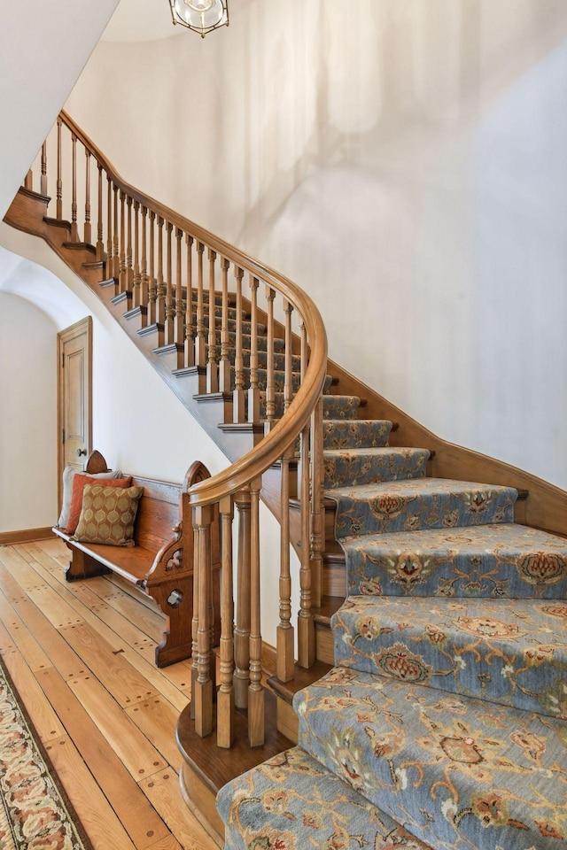 stairs featuring a high ceiling and hardwood / wood-style flooring