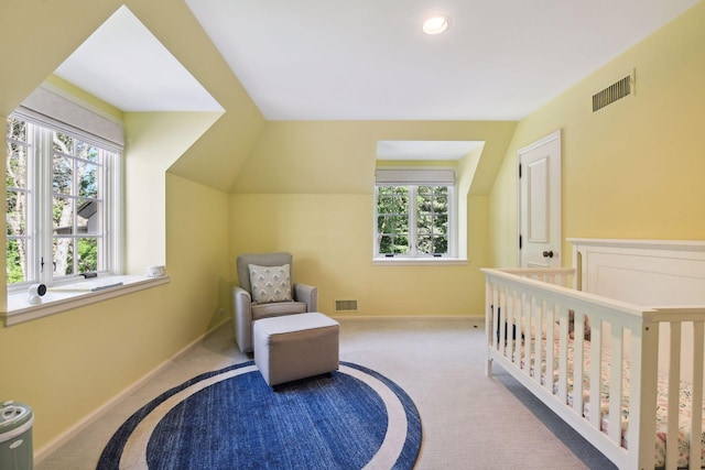 carpeted bedroom with vaulted ceiling, a nursery area, baseboards, and visible vents