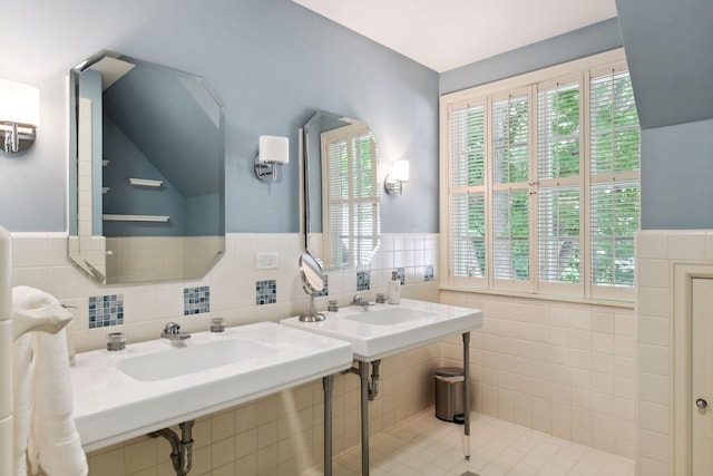 bathroom with tile walls, wainscoting, and a sink