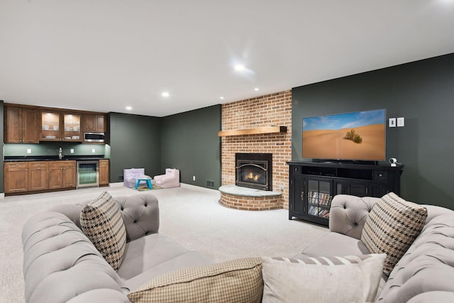 living area with light carpet, beverage cooler, recessed lighting, a fireplace, and indoor wet bar