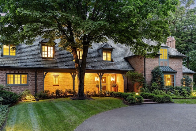 view of front of property featuring brick siding and a front lawn