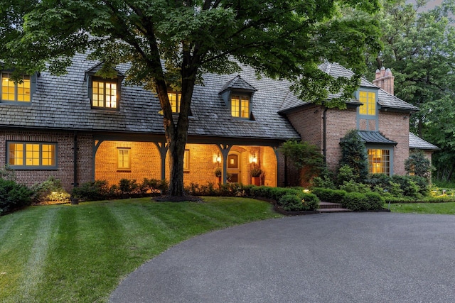 view of front of home featuring brick siding and a front yard