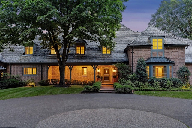 view of front facade with brick siding and a front lawn