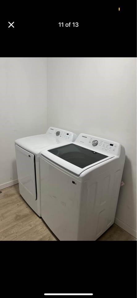 laundry area featuring laundry area, washing machine and dryer, light wood-style floors, and baseboards