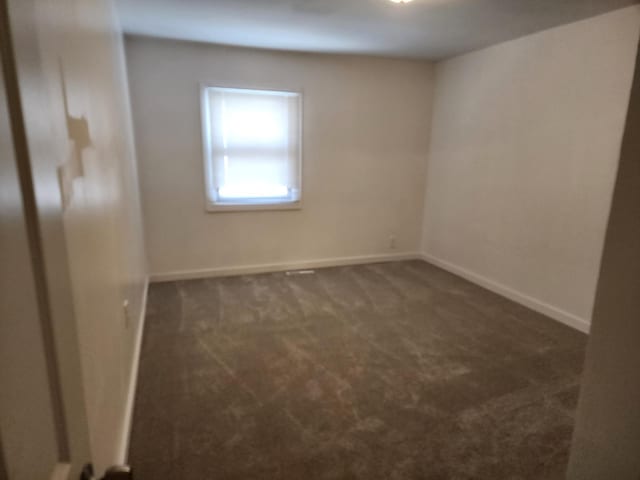 empty room featuring carpet and baseboards