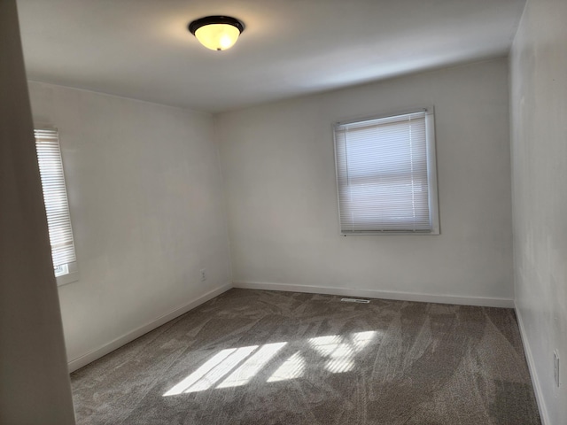 carpeted spare room featuring baseboards