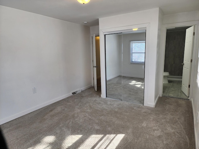 unfurnished bedroom with a closet, visible vents, carpet flooring, and baseboards