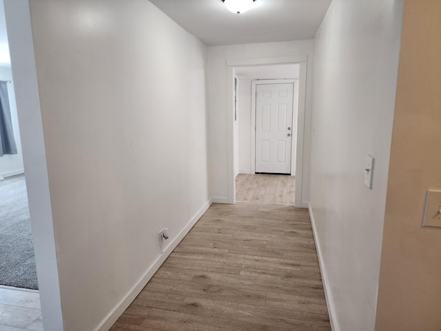 corridor featuring wood finished floors and baseboards