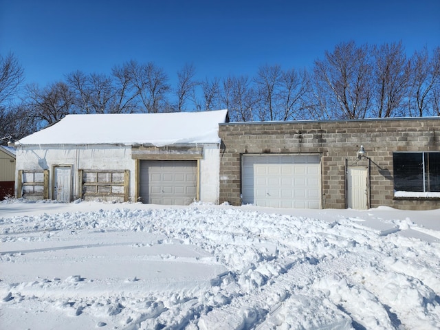 snow covered garage featuring a garage