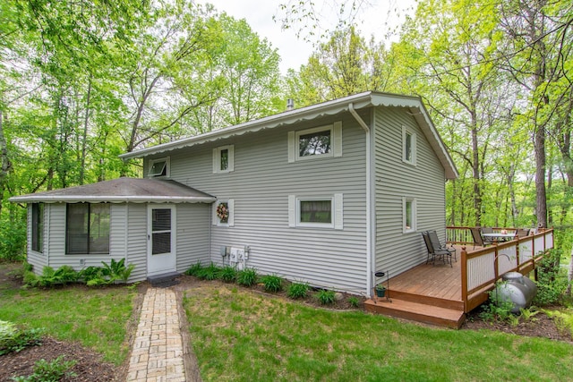 back of house with a lawn and a wooden deck