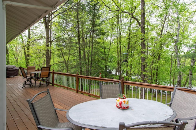 deck with outdoor dining area and grilling area