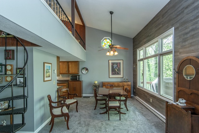 dining space with baseboards, a ceiling fan, carpet, a high ceiling, and a baseboard heating unit