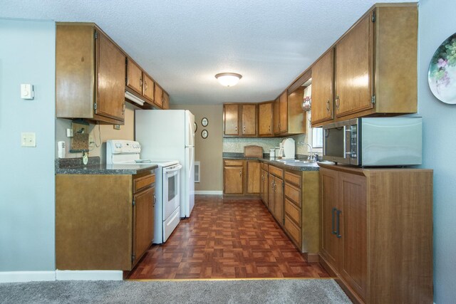 kitchen featuring white electric range, stainless steel microwave, dark countertops, and brown cabinetry