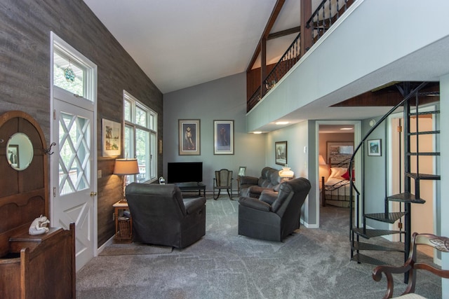 living area with carpet, stairs, and high vaulted ceiling