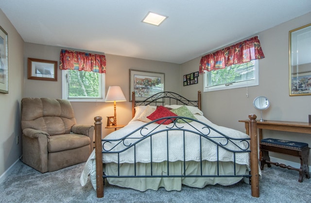 carpeted bedroom featuring multiple windows and baseboards