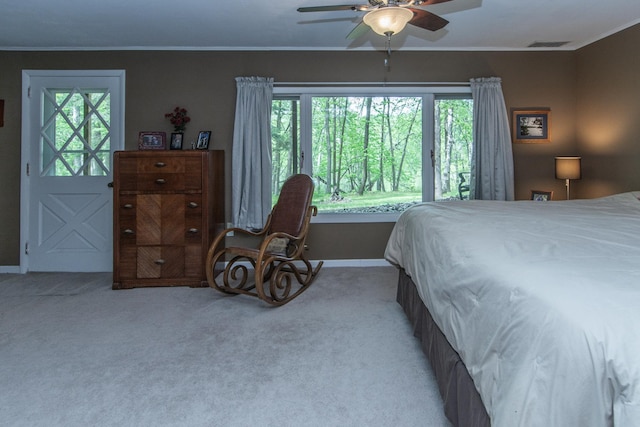 carpeted bedroom featuring ornamental molding, visible vents, and multiple windows