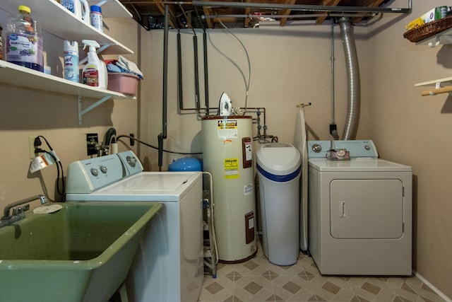 clothes washing area with light floors, electric water heater, a sink, separate washer and dryer, and laundry area