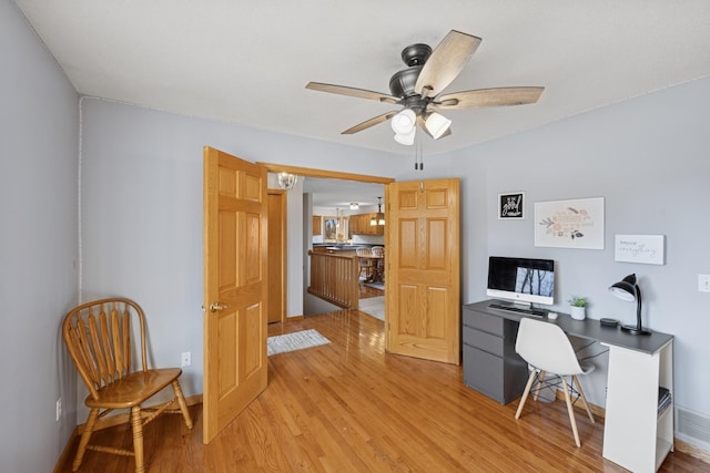 home office featuring light wood-style flooring and a ceiling fan