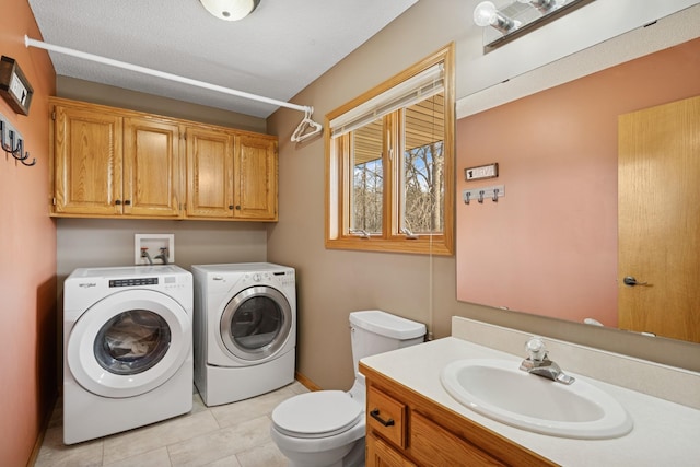 washroom featuring light tile patterned floors, laundry area, separate washer and dryer, and a sink