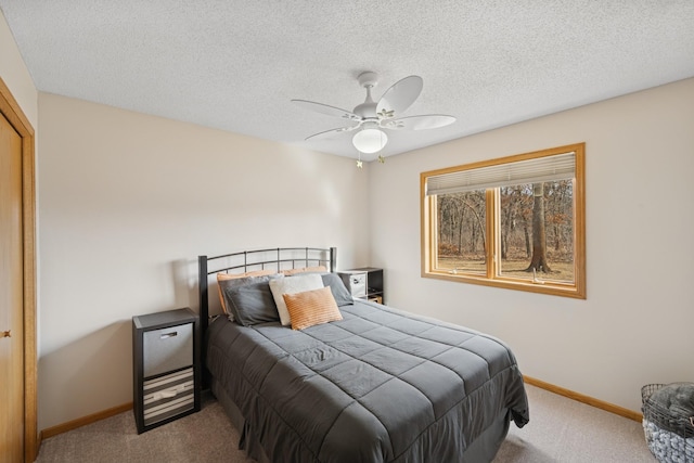 bedroom featuring a textured ceiling, baseboards, and carpet floors