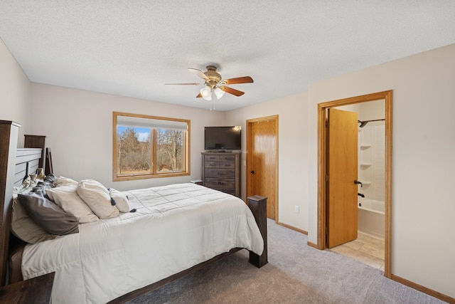 bedroom with connected bathroom, ceiling fan, baseboards, light carpet, and a textured ceiling