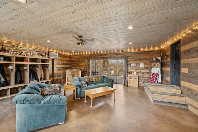 living area featuring wooden ceiling, concrete floors, wood walls, and a ceiling fan