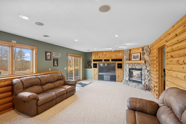 carpeted living area featuring rustic walls, plenty of natural light, a textured ceiling, and recessed lighting