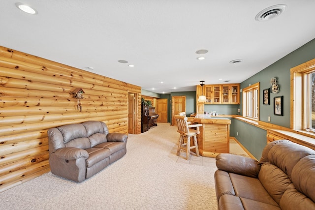 living area with visible vents, log walls, recessed lighting, bar area, and light carpet