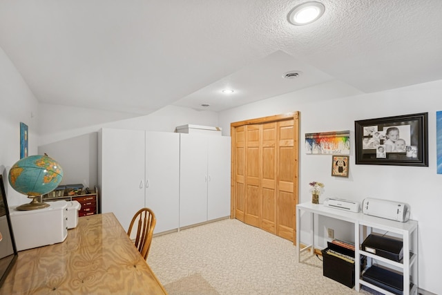 office area with carpet flooring, visible vents, and a textured ceiling