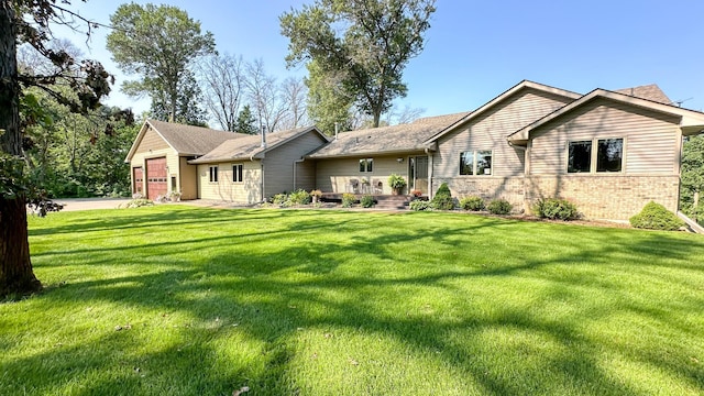 ranch-style home featuring a front yard, a garage, and brick siding